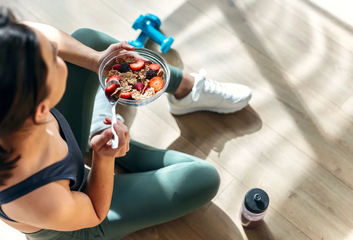 Woman in exercise clothes eating foods to help her joint health.