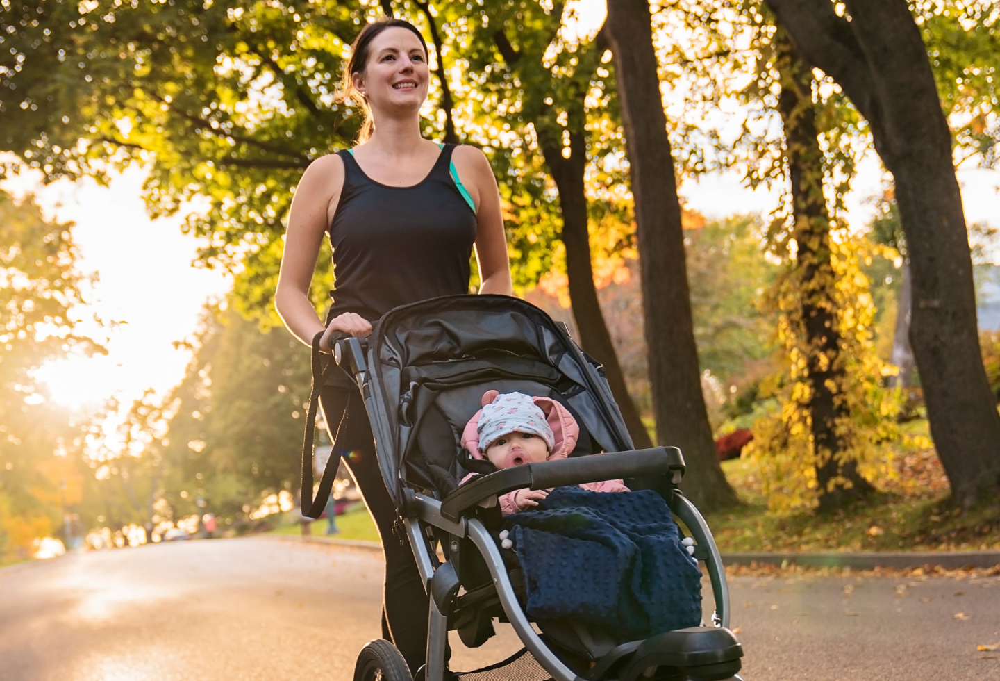 Woman returning to running postpartum after pelvic floor therapy, on a run with her baby in a jogger