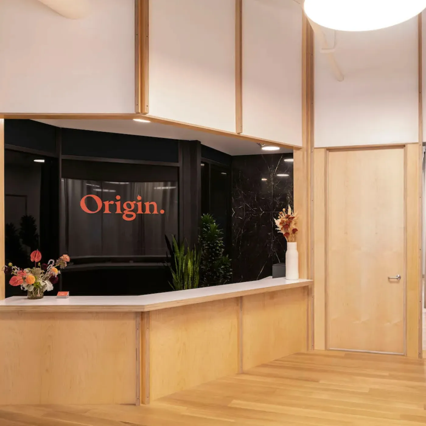 The brightly lit, cheerful front desk at Origin.