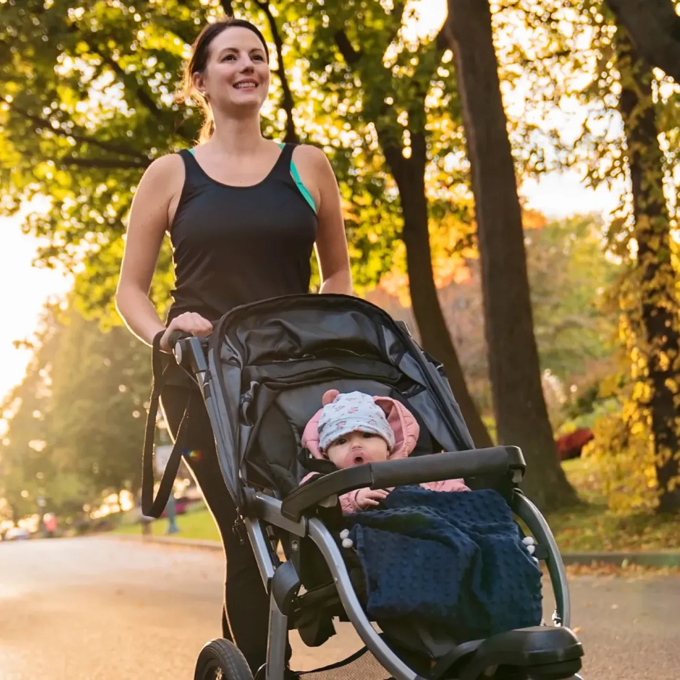 Woman returning to running postpartum after pelvic floor therapy, on a run with her baby in a jogger.