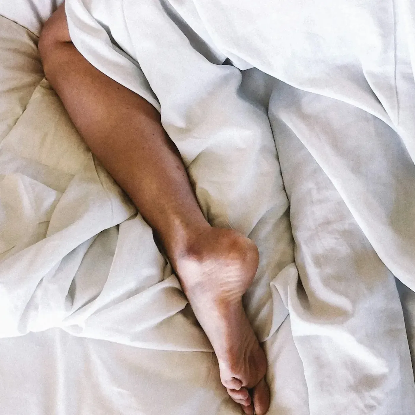 A woman with uterine prolapse lying in bed wondering if it's safe to have sex.