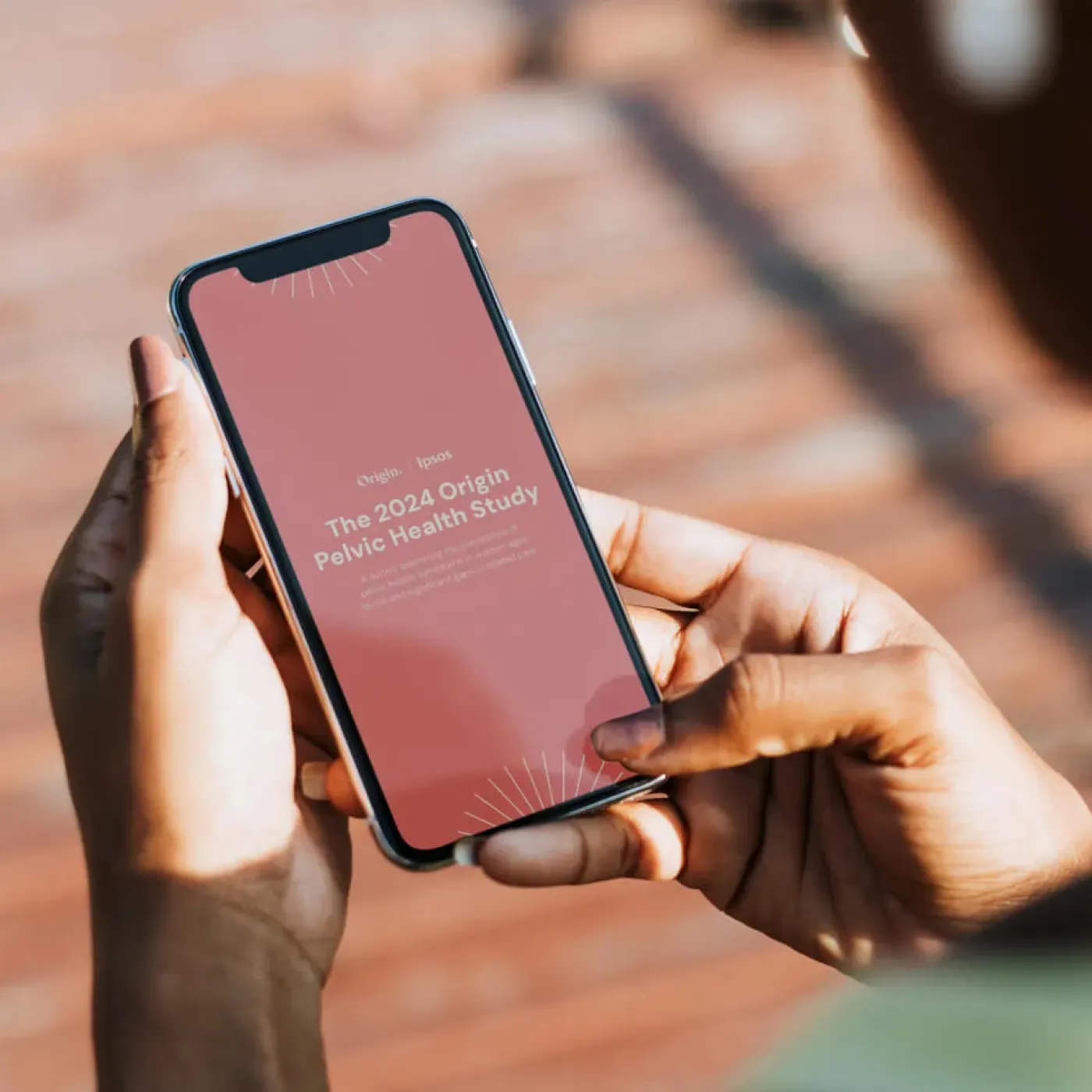 A woman reading the 2024 Origin Pelvic Health Study on her mobile phone.