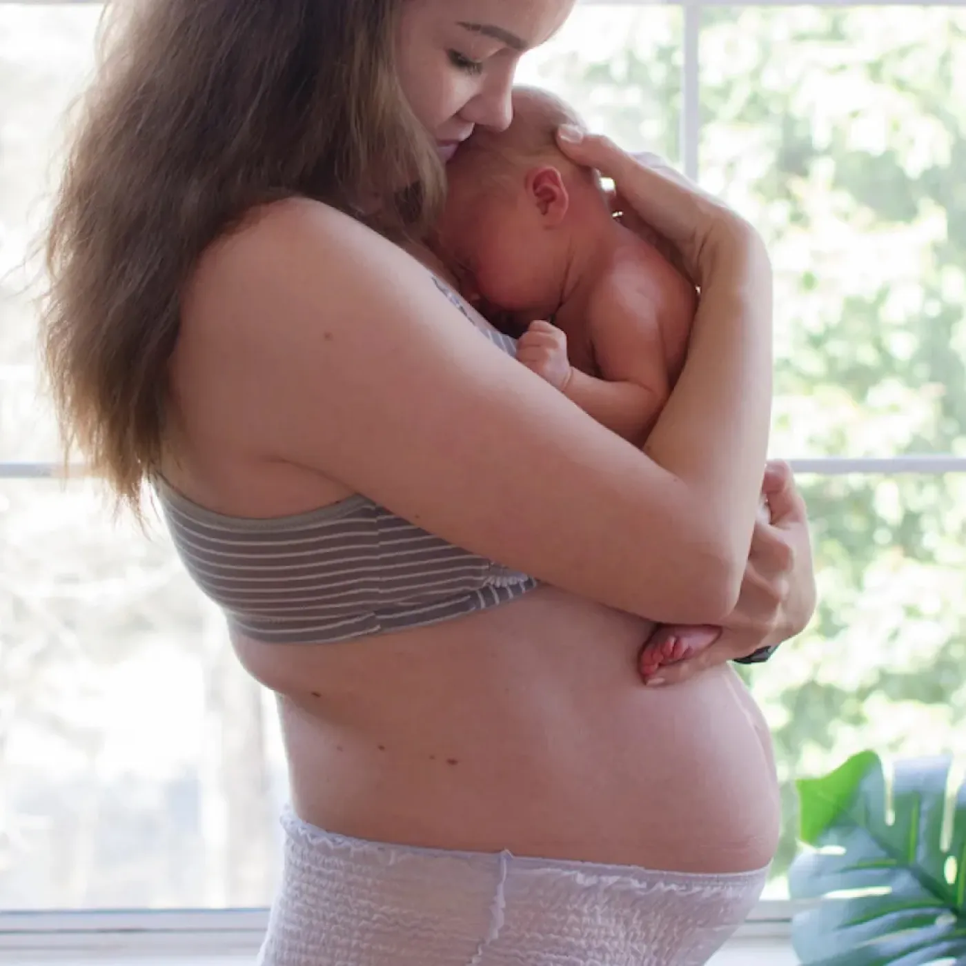 A postpartum mom holding her newborn.