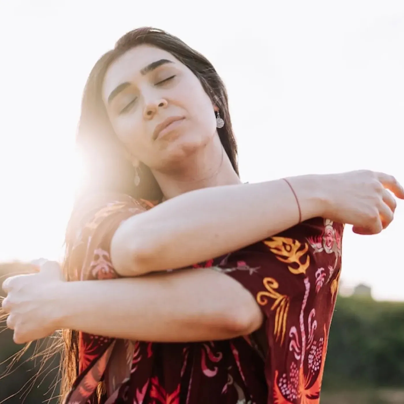 A woman wrapping her arms around herself for a story on pelvic healing after sexual assault.