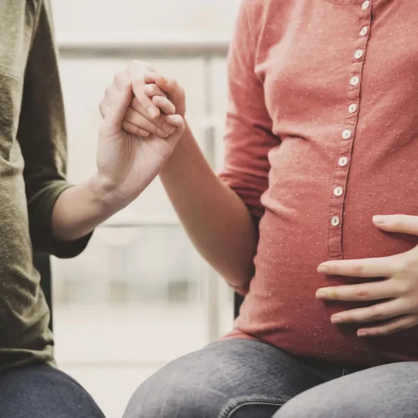 Pregnant women holding hands in a tokophobia support group.