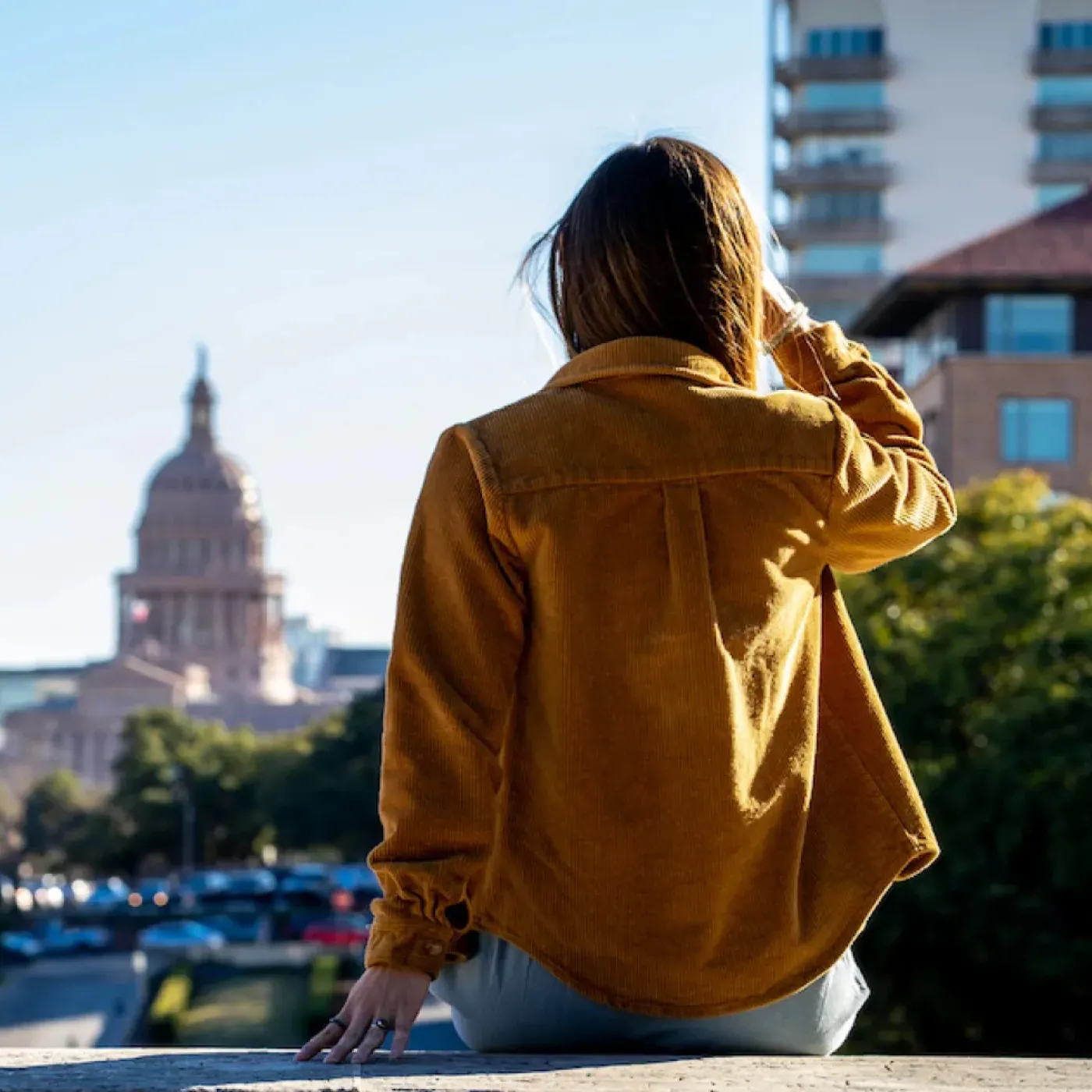 A woman doing her Origin physical therapy exercises in a park in Austin.