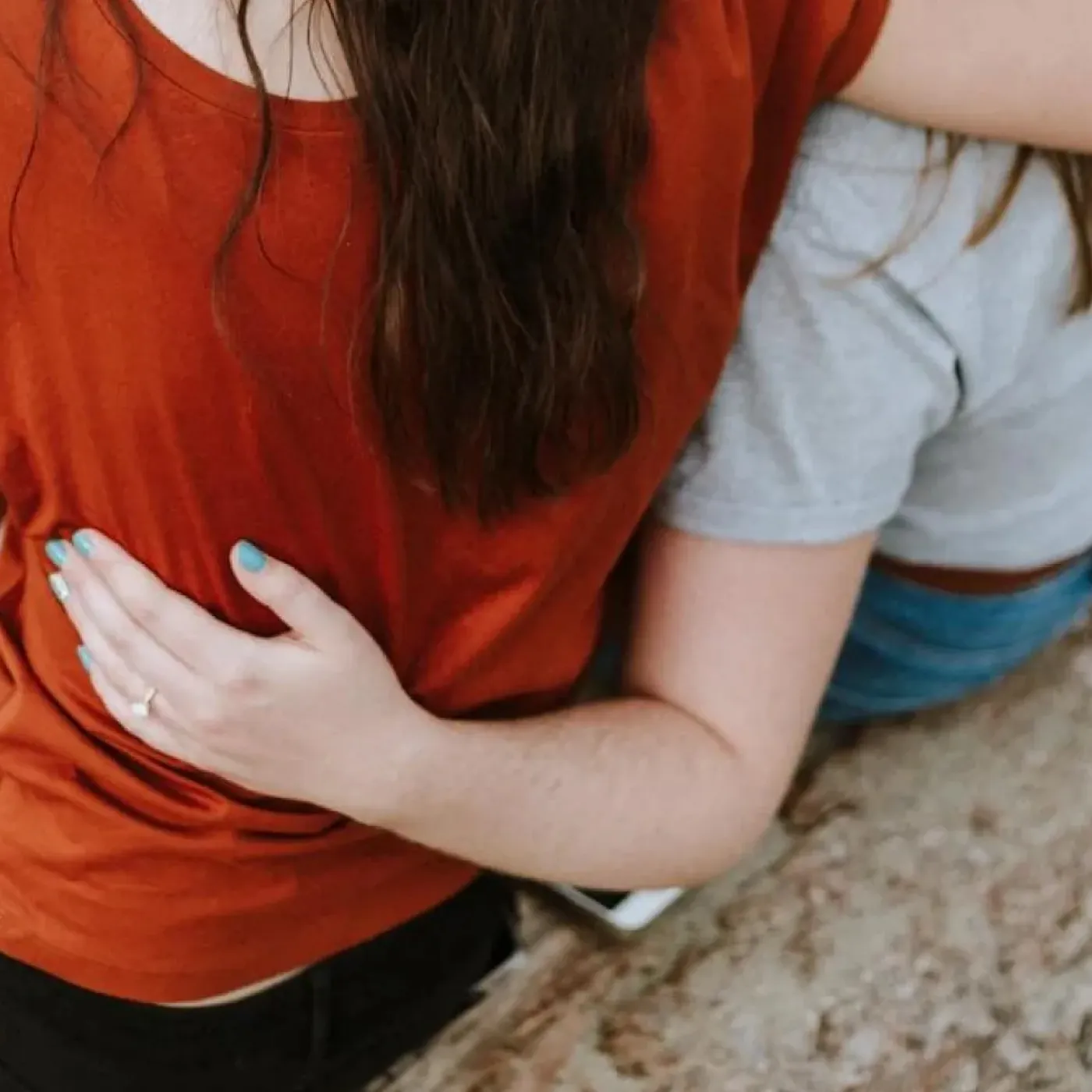 Three women with their arms around each other for support.