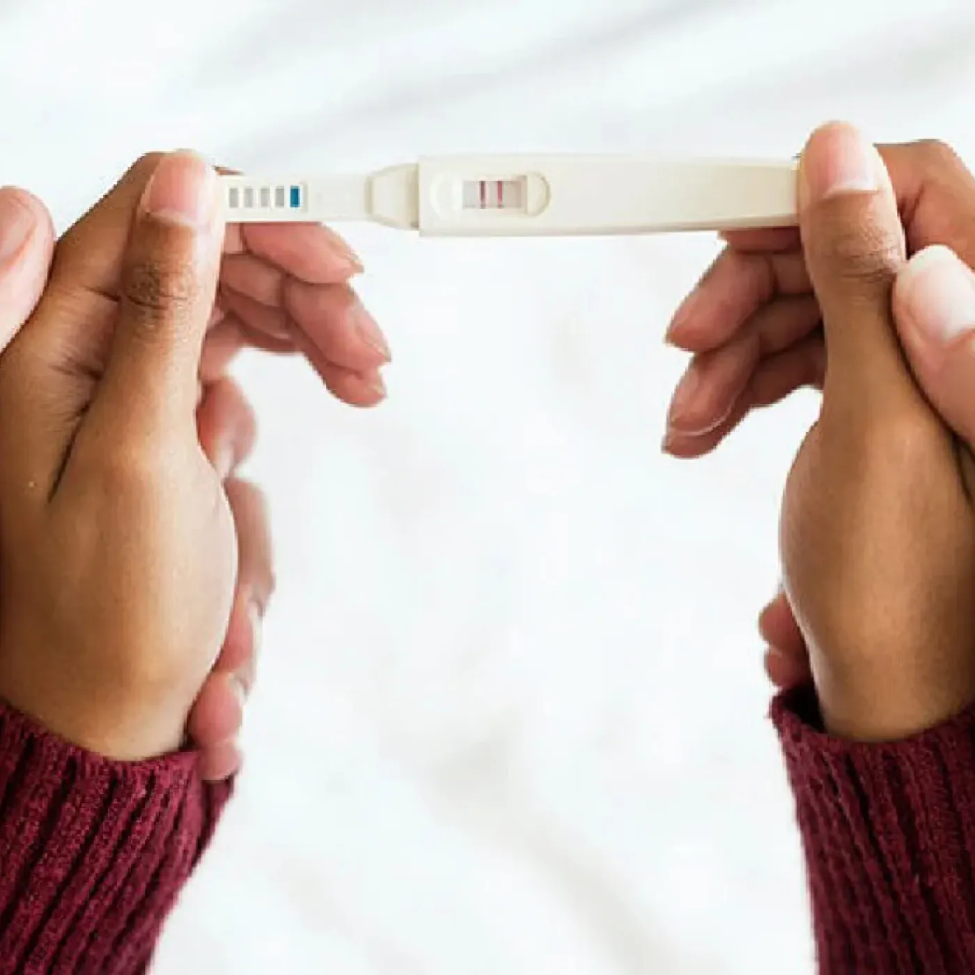 Woman's & man's hands holding a positive pregnancy test.