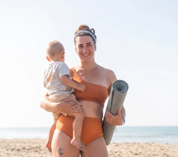Woman and her baby traveling in the summer representing travel and pelvic health.