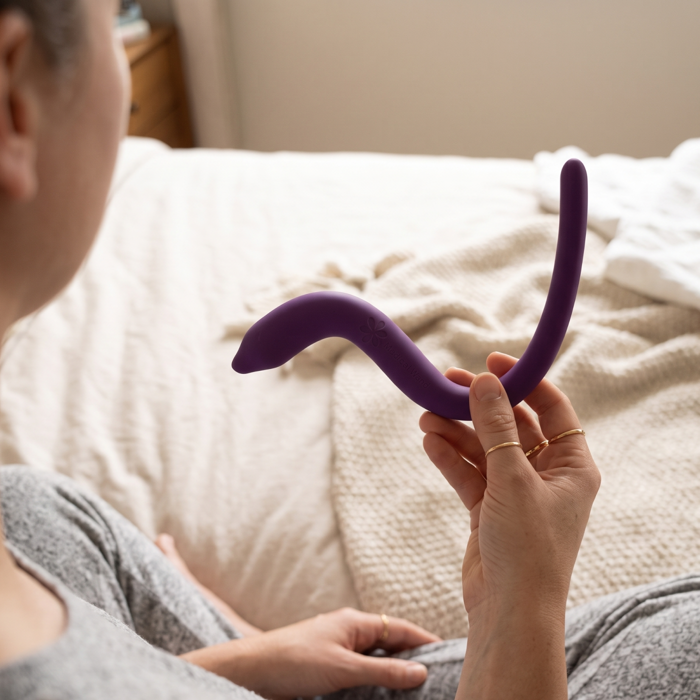 Woman holding up intimate rose pelvic floor wand for pelvic floor myofascial release
