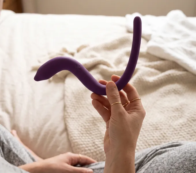 Woman holding up intimate rose pelvic floor wand for pelvic floor myofascial release.