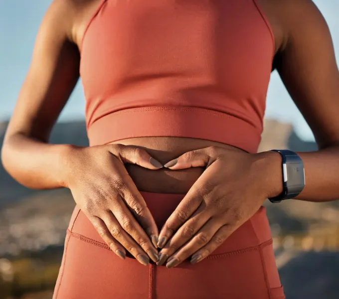 Woman holding her abdomen, representing Origin’s 2026 State of Pelvic health Report.