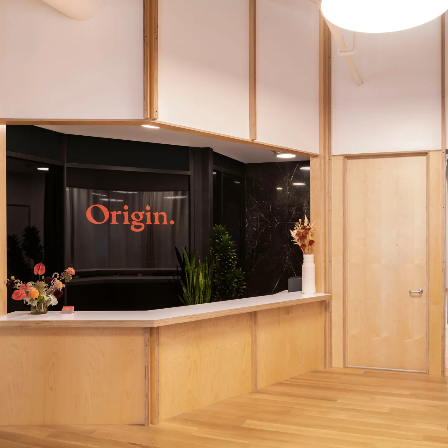 The brightly lit, cheerful front desk at Origin.