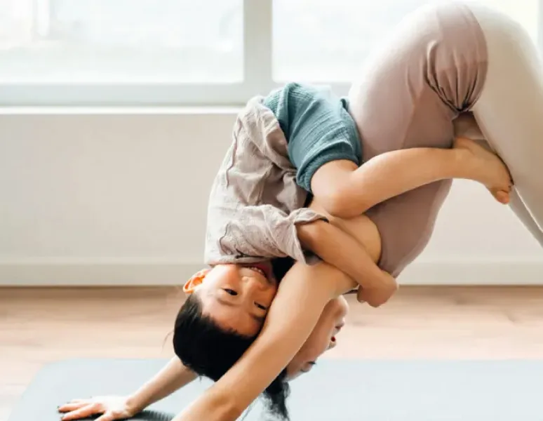 Woman doing yoga with child.