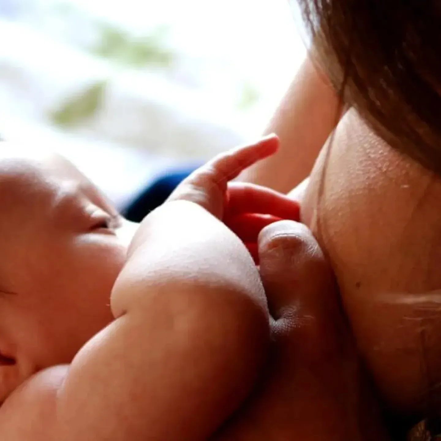 Woman breastfeeding while reducing shoulder, back, neck & wrist pain.