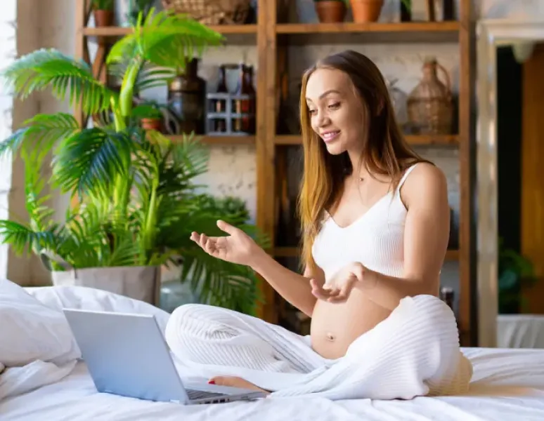 A pregnant woman having a virtual visit with a pelvic floor physical therapist.