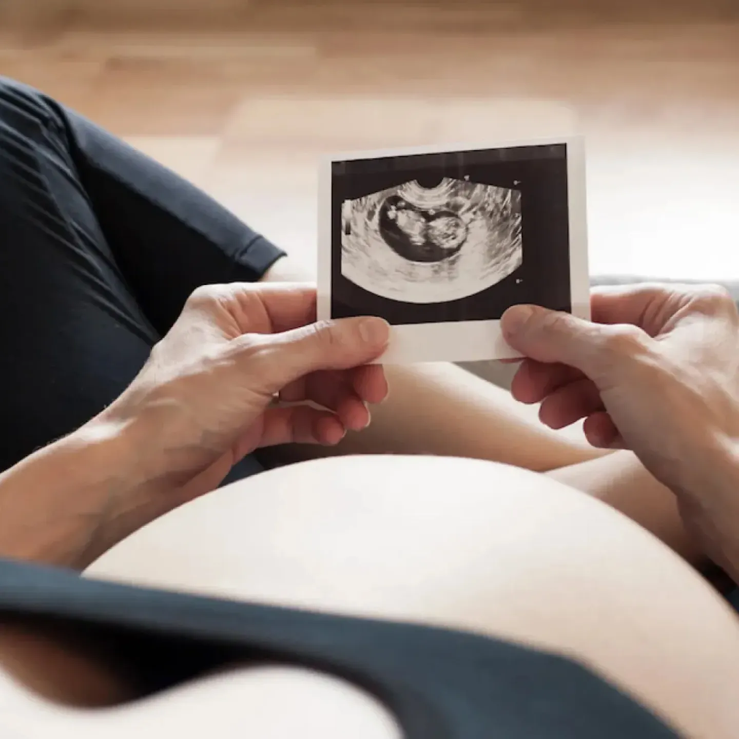 A pregnant woman looking at an ultrasound image and worrying about gestational diabetes.