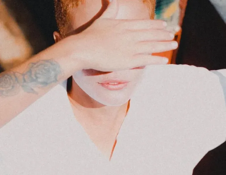 An image of a woman covering her eyes for an Informative Story On HPV And Cervical Cancer.