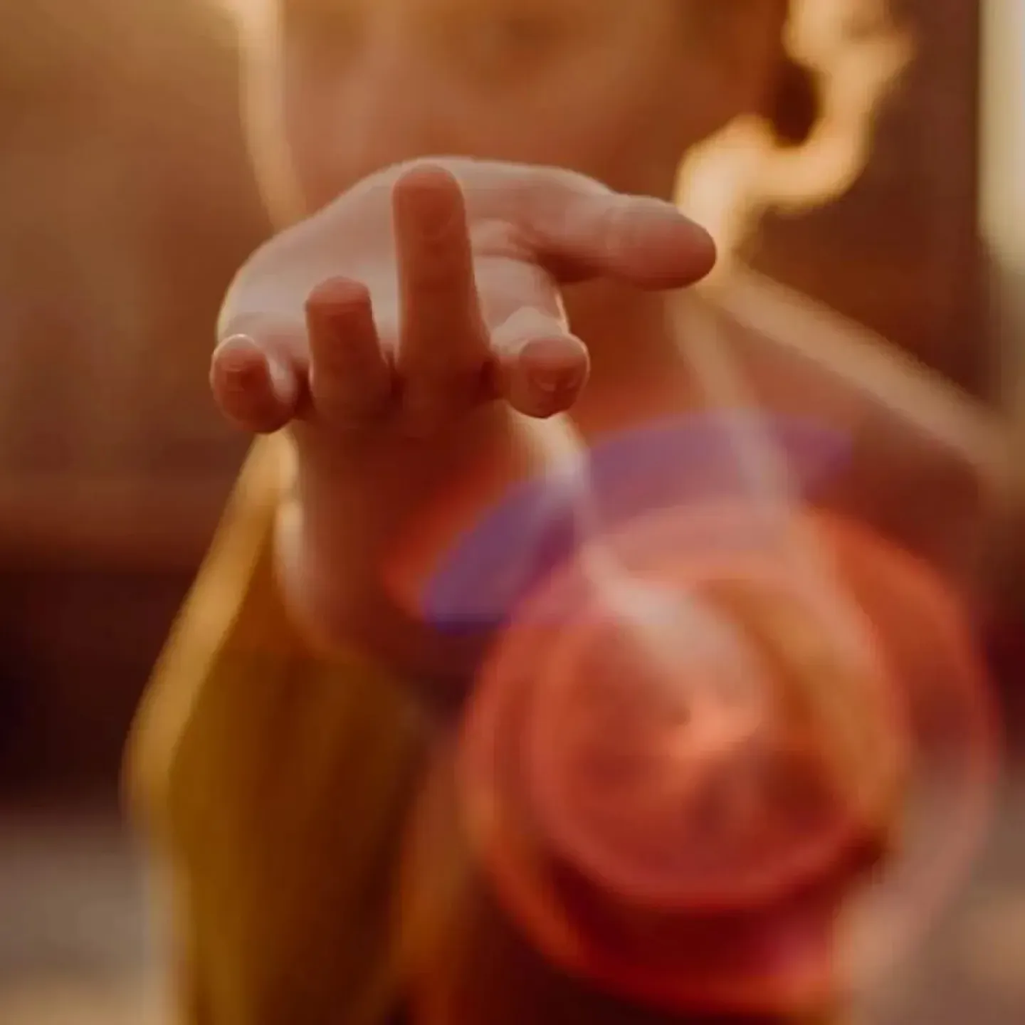A woman holding up her hand surrounded by light to symbolize the pleasure of pelvic floorgasm.
