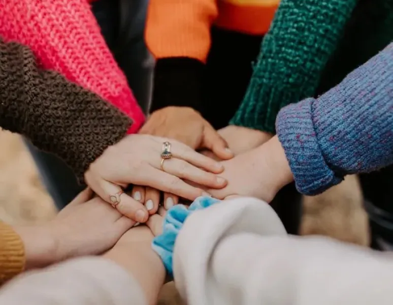 Women putting their hands together for amazing researchers in women's health.