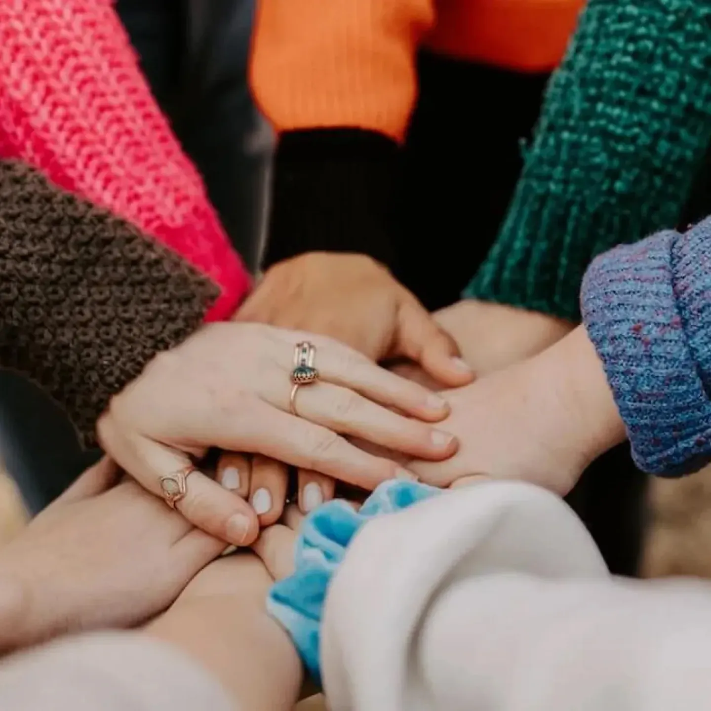 Women putting their hands together for amazing researchers in women's health.