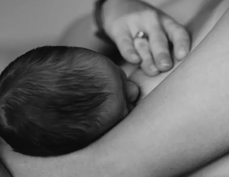 A woman holding her postpartum breasts.