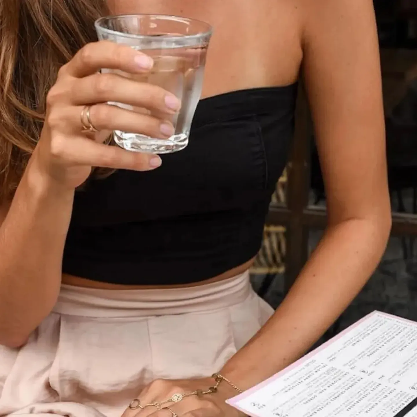 Woman drinking water in a restaurant.