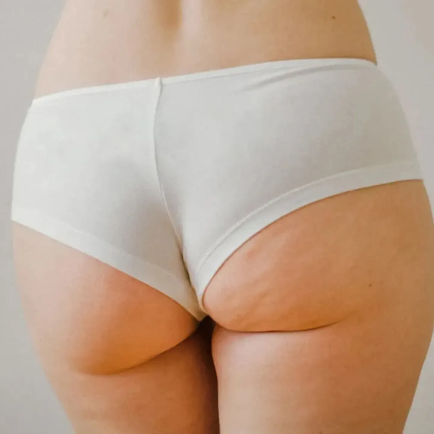 A woman shown from behind wearing white underwear, for a story on anal kegels and the pelvic floor.