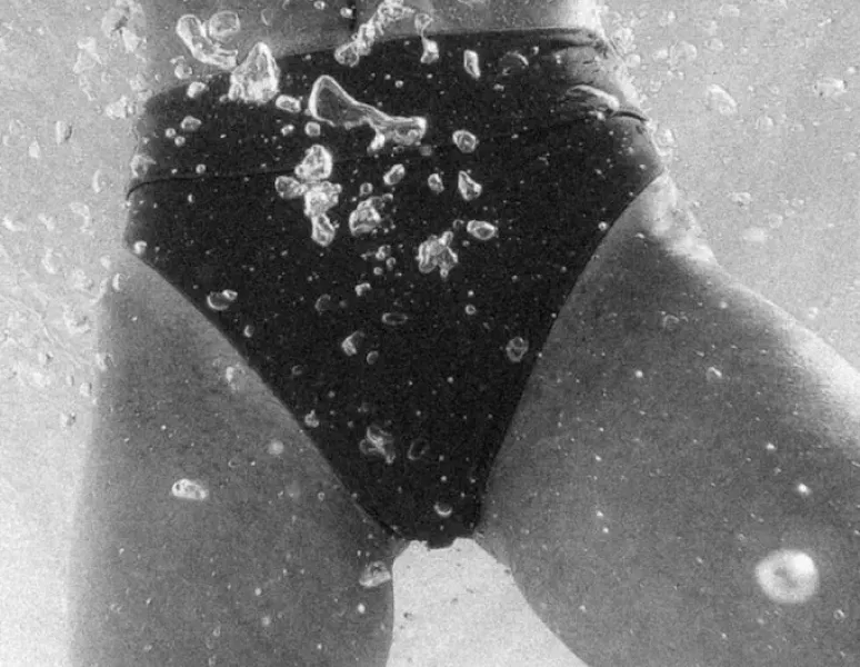 A Black & White photo of a woman's pelvic area underwater.