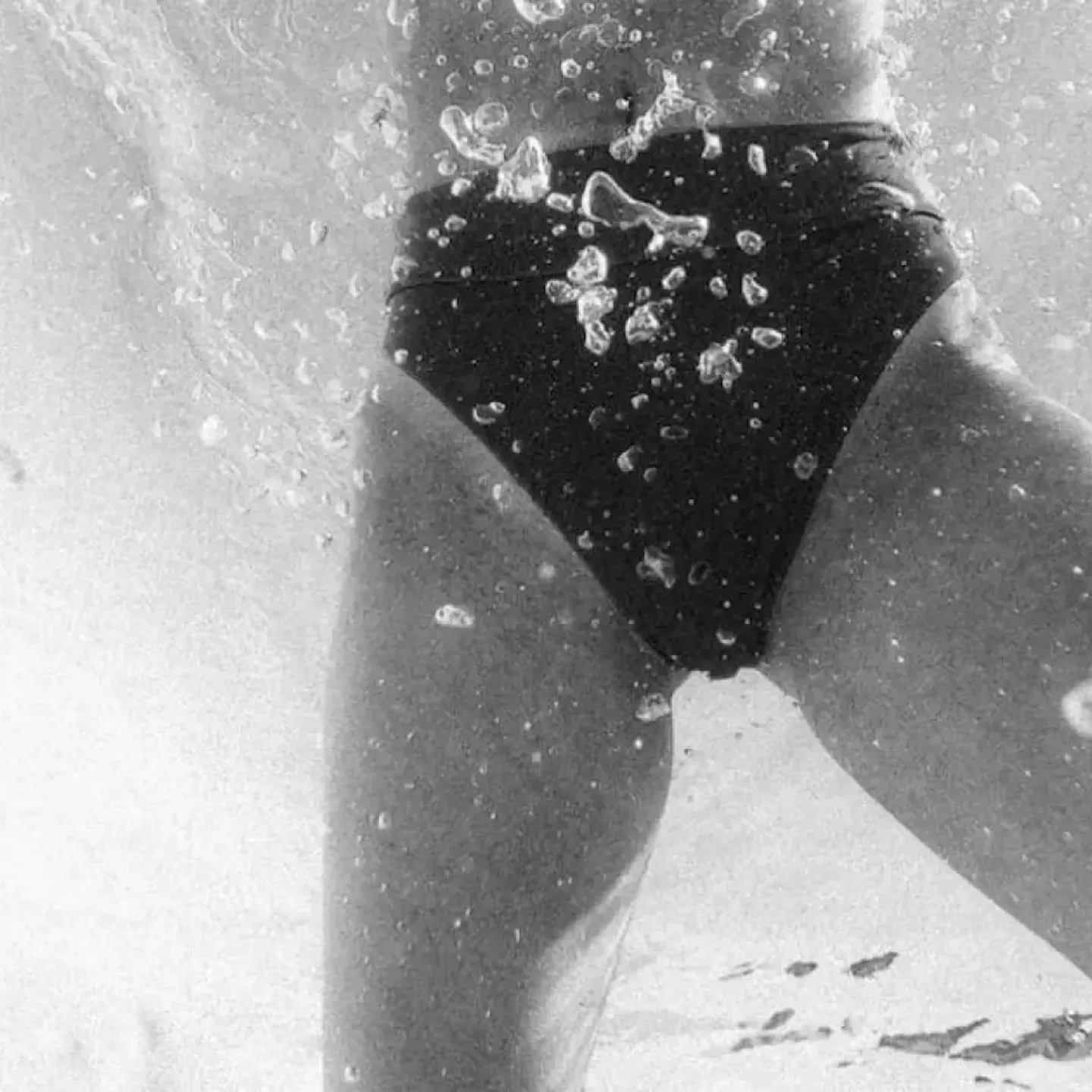 A Black & White photo of a woman's pelvic area underwater.