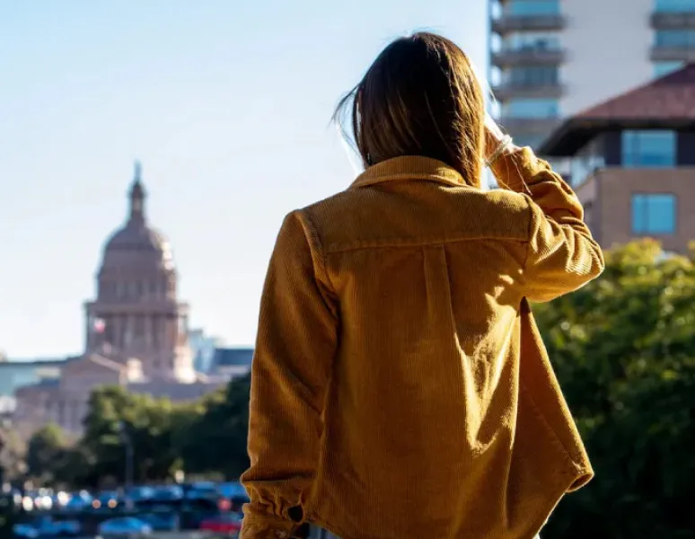 A woman doing her Origin physical therapy exercises in a park in Austin.