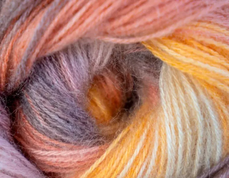 A skein of yarn shown close-up from the side — the whole in the center of the yarn is a metaphor for an anus with rectal prolapse.