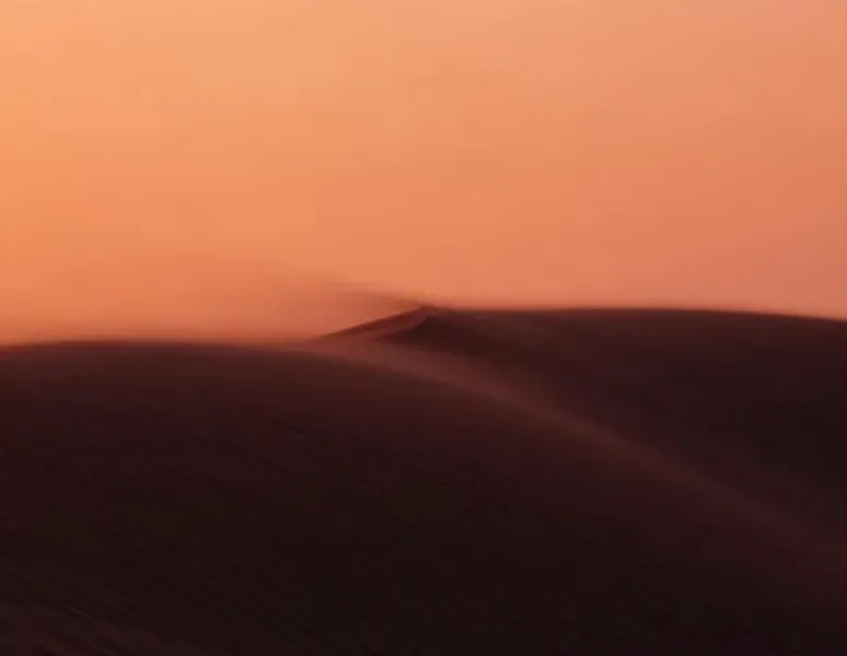 A photograph of sand dunes under a red sky to represent a dry vulva an vagina for a story on vaginal dryness before menopause.