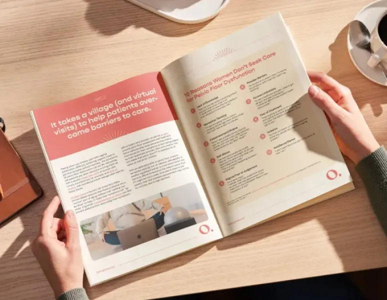 A woman at a sunlit desk is eating coffee and reading Origin's State of Pelvic Floor Physical Therapy report.
