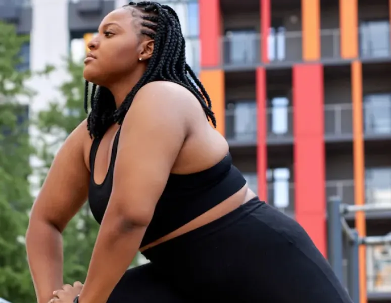 A woman exercising in a city park to help relieve her postpartum low back pain.
