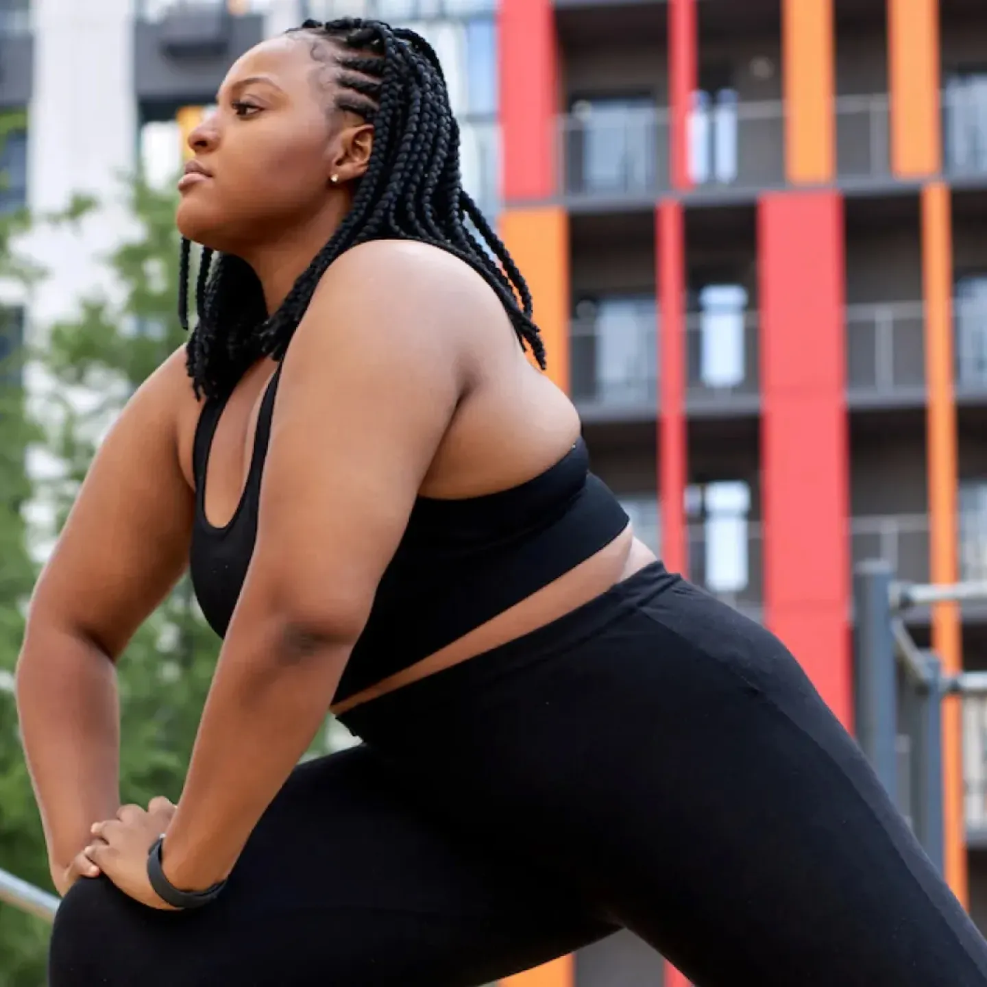 A woman exercising in a city park to help relieve her postpartum low back pain.