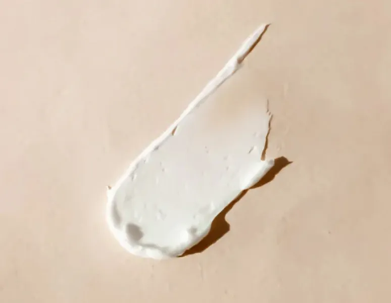 White orgasm enhancing cream on a beige background.