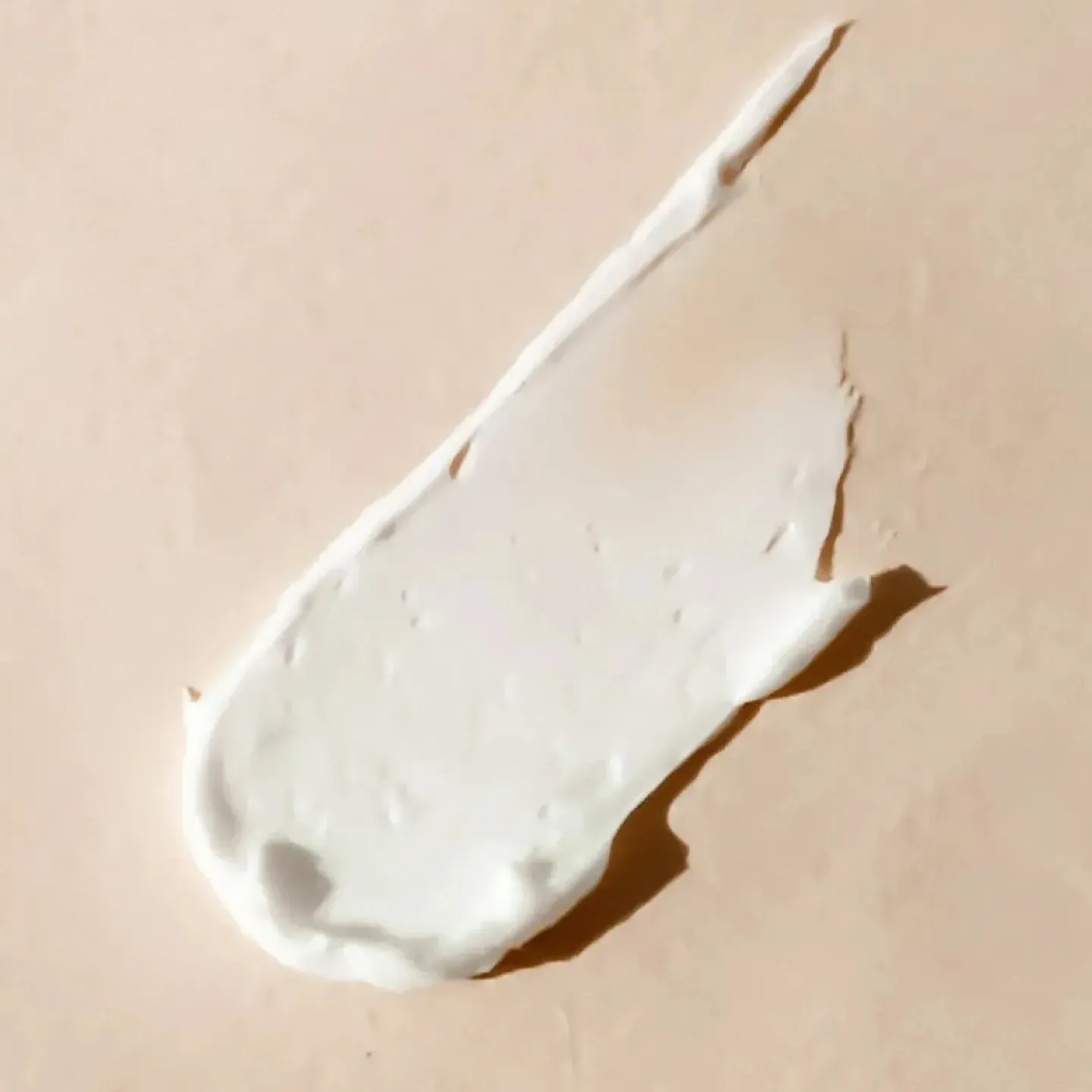 White orgasm enhancing cream on a beige background.