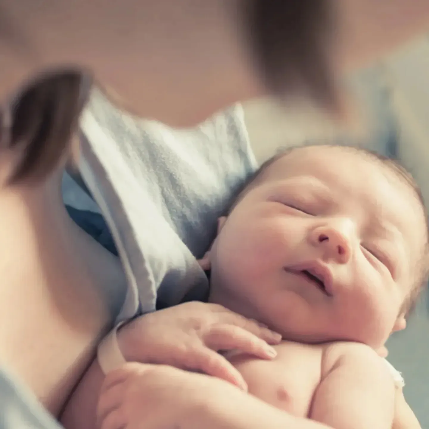 A new mother holding her newborn baby for a story on episiotomy and perineal tear recovery.
