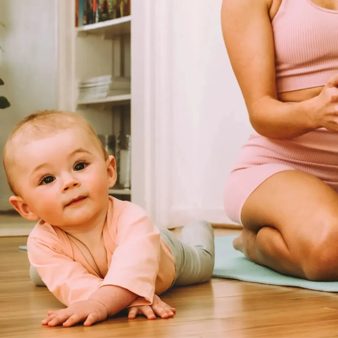 A new mom doing virtual physical therapy at home with her baby.