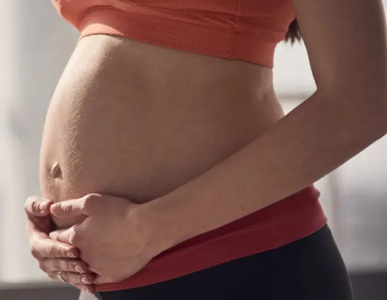 A pregnant woman in her third trimester doing yoga to relieve low back pain.