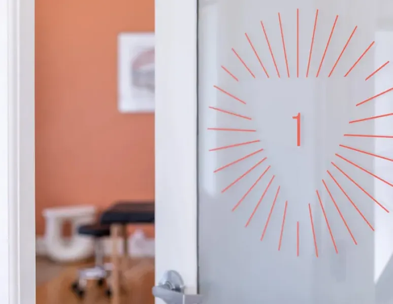 Clinic doors opening into the spa-like treatment rooms at Origin Physical Therapy.