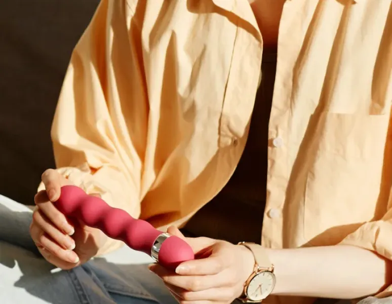A woman holding a pelvic floor strengthening kegel trainer.