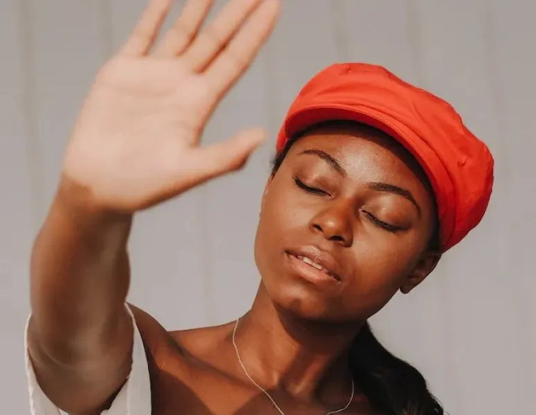 A black woman holding up her hand for a story about medical gaslighting and female pain.