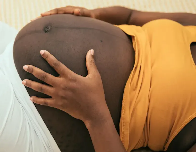 A pregnant woman holding her belly.