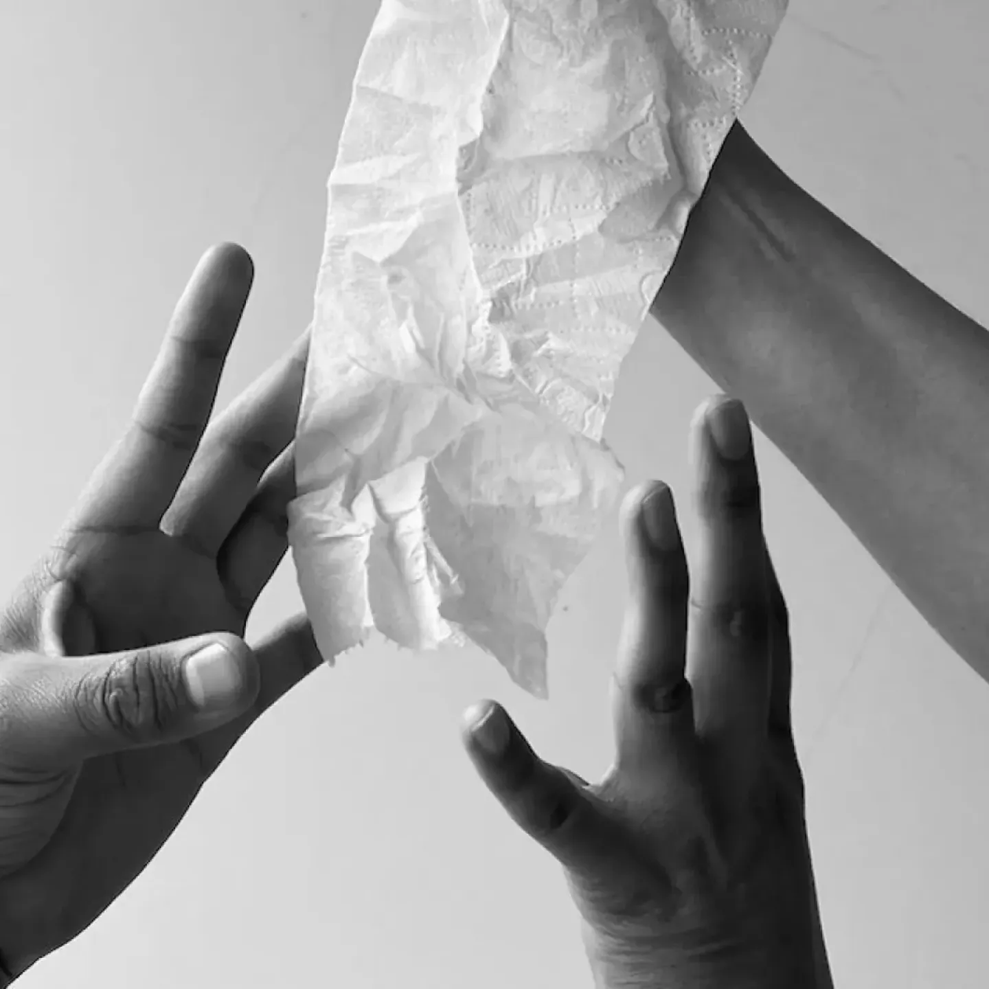 A woman's hand holding out a roll of toilet paper for a story on endless wiping after bowel movements.