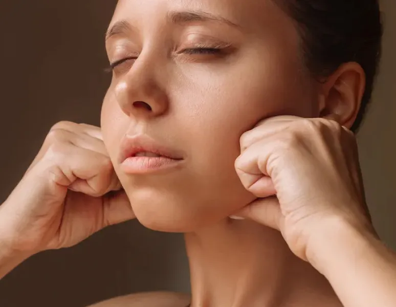 A woman getting jaw massage from a pelvic floor Physical Therapist.