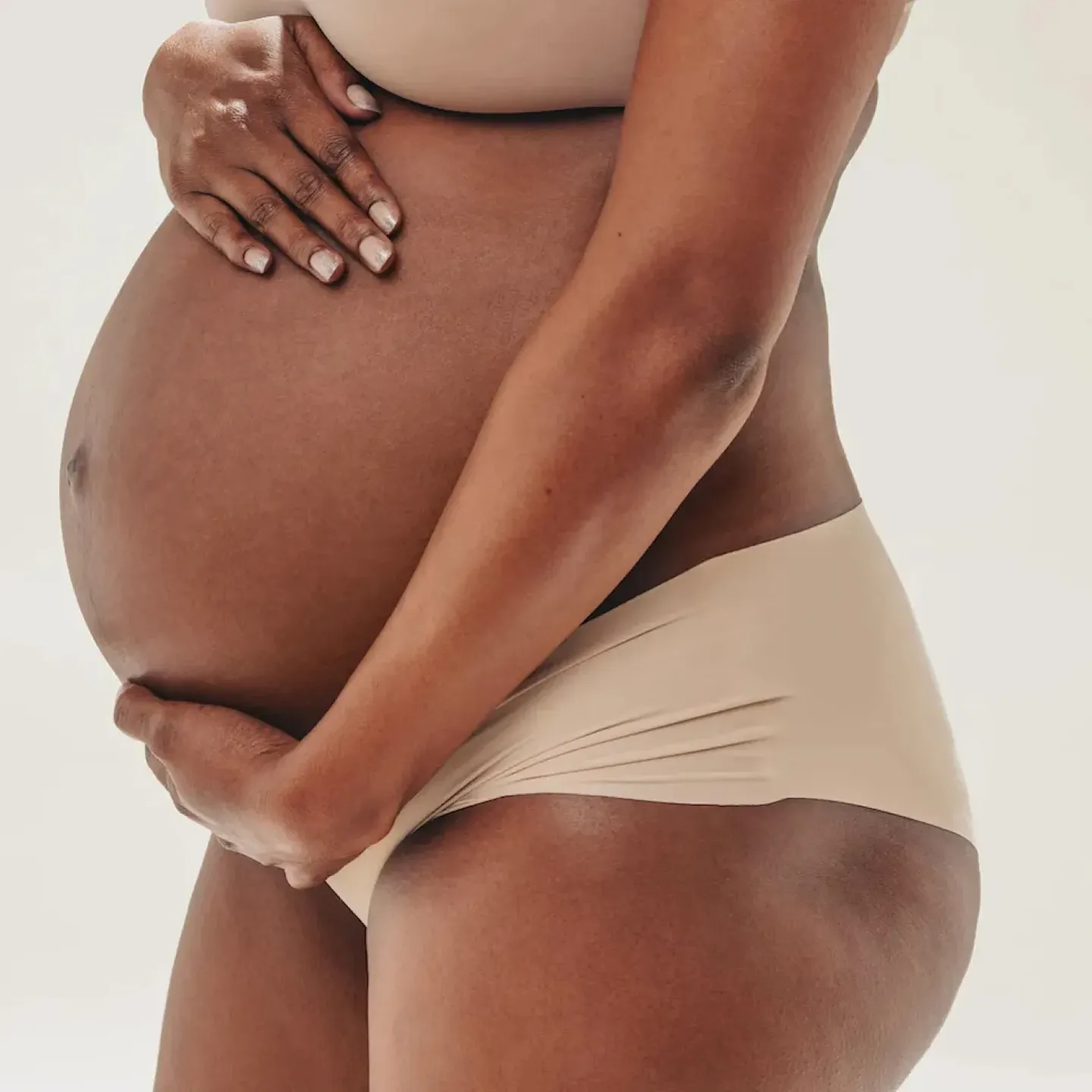 A pregnant woman with pelvic pain lying on a yoga mat at home.
