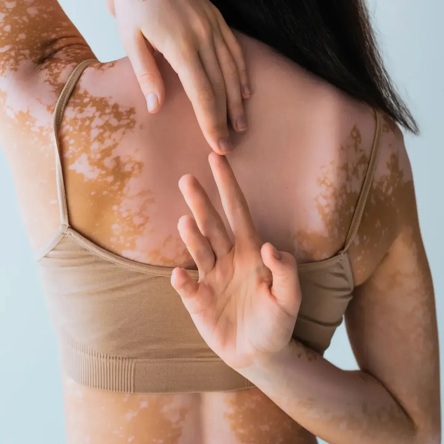 A woman touching the tips of her fingers behind her back for a story on hypermobility.