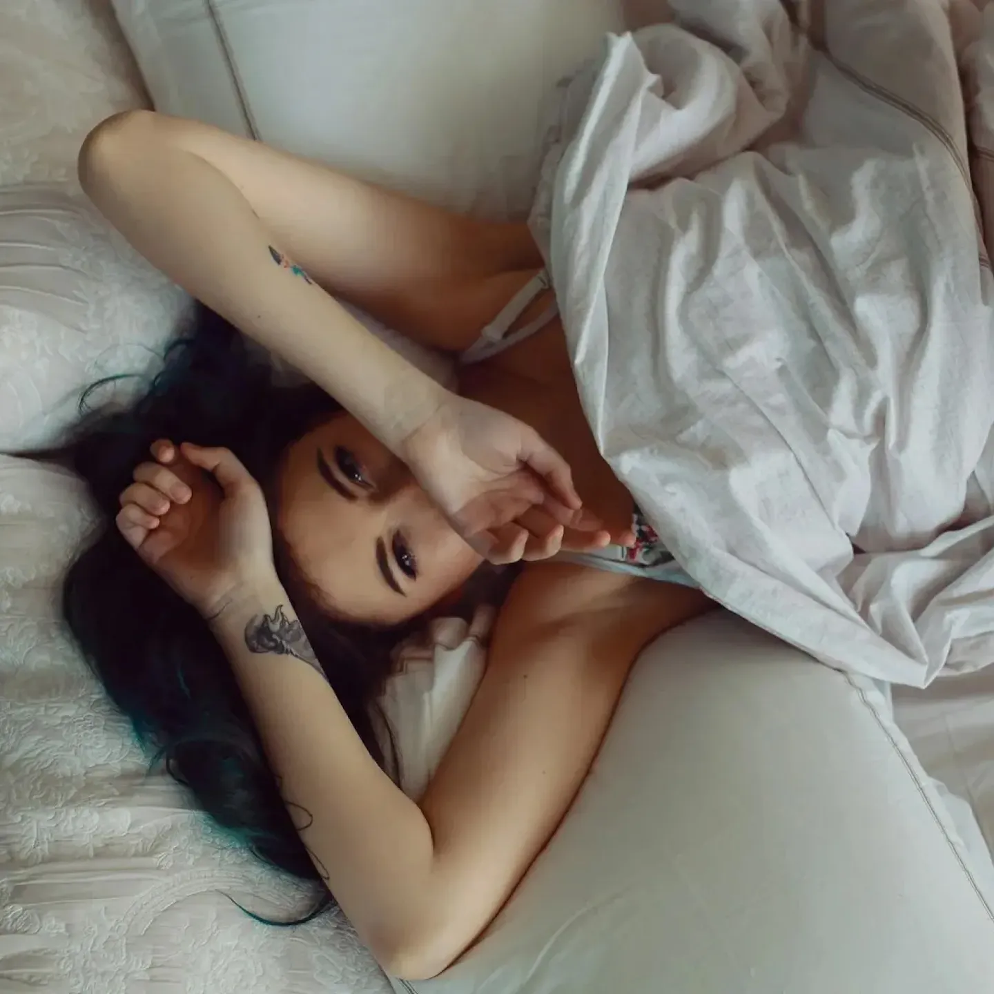 A woman lying in bed upset because she peed during sex.